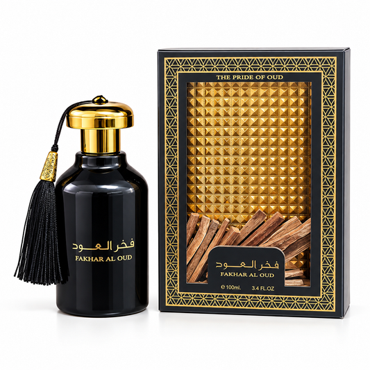 Fakhar Al Oud perfume bottle in glossy black glass with a gold cap and black tassel, shown next to its black and gold retail box featuring a gold pyramid pattern and a window view of wood slices.