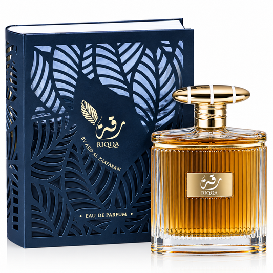 A bottle of RIQQA By Awd Al Zaafaran Eau De Parfum with amber-colored liquid, shown next to its navy blue and gold patterned packaging box on a white background.