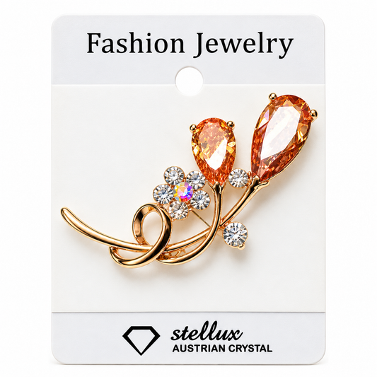 A gold-tone fashion jewelry brooch featuring two peach-colored teardrop crystals and a small flower with a clear iridescent center, mounted on a white display card labeled 'Fashion Jewelry' and 'stellux AUSTRIAN CRYSTAL'.
