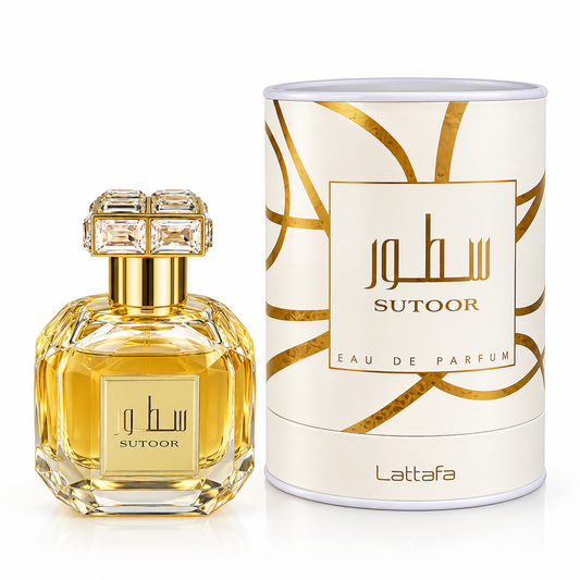 Sutoor Lattafa Eau de Parfum bottle with a faceted gold glass body and crystal cap, shown next to its white cylindrical packaging box with gold patterns.