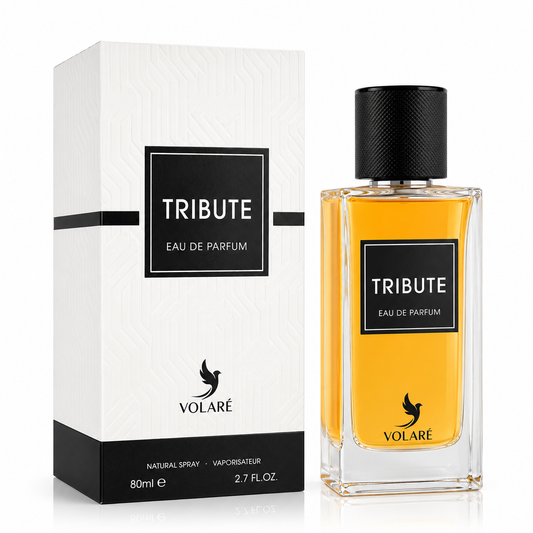 A bottle of VOLARÉ Tribute Eau de Parfum with golden-yellow liquid and a black cap, shown next to its white and black packaging box on a clean white background.
